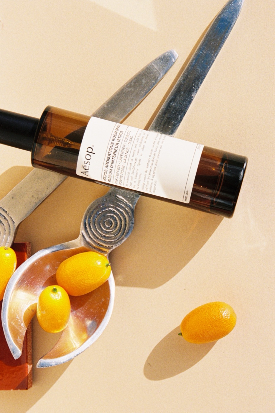 Aesop room spray styled alongside vintage spoons and kumquats