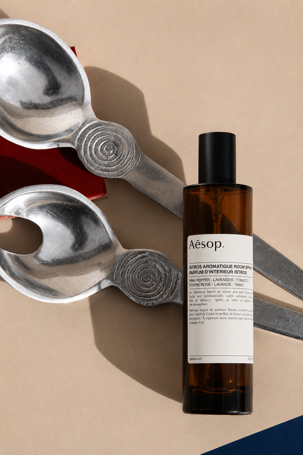Aesop room spray styled alongside vintage spoons, side angle